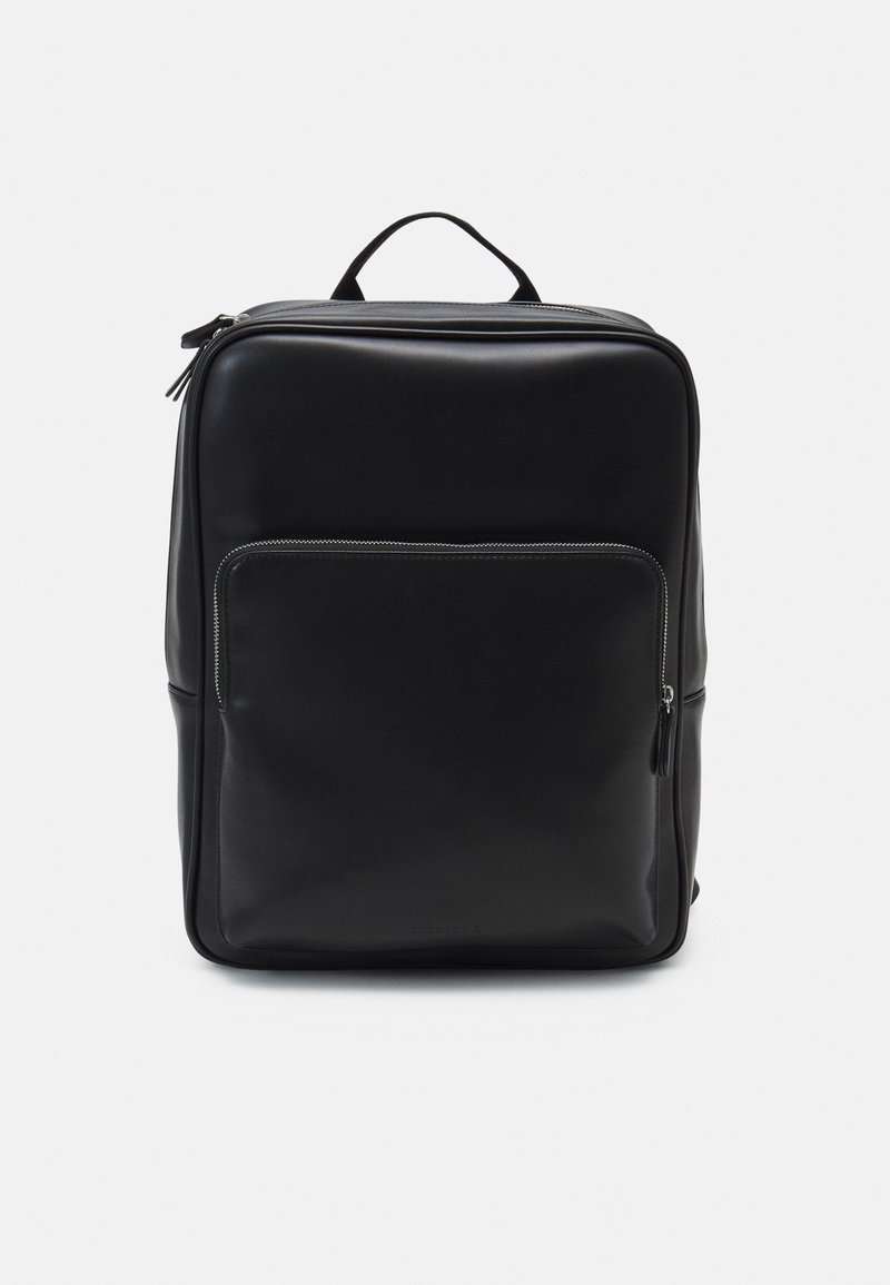 Mochila negra de cuero con una textura suave, que cuenta con un bolsillo frontal con cremallera, un asa superior y un diseño minimalista.
