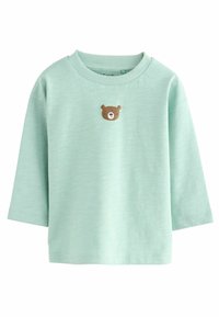 Chemise à manches longues vert menthe en tissu doux, avec une petite application du visage d'un ours brun sur la poitrine. Encolure et poignets côtelés.