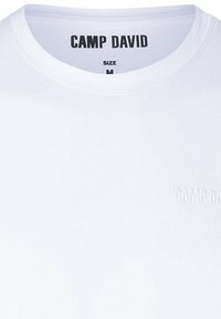 T-shirt bianca in cotone con collo a giro, logo goffrato "CAMP DAVID" discreto e etichetta di misura standard M all'interno del collo.