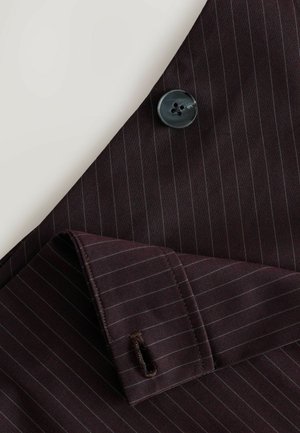 Țesătură de costum burgund închis cu un model subtil de dungi, având un nasture negru cu patru găuri și detaliu la manșetă pliat cu cusături.