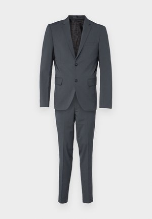Donkergrijs kostuum bestaande uit een op maat gemaakte blazer met twee knopen en bijpassende slim-fit broek. Glad stof met een subtiele textuur.