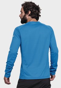 Langärmliges Sportoberteil in lebhaftem Blau, mit strukturiertem Stoff und nahtlosem Schulterdesign. Die Rückseite ist schlicht gehalten und hat einen Rundhalsausschnitt.