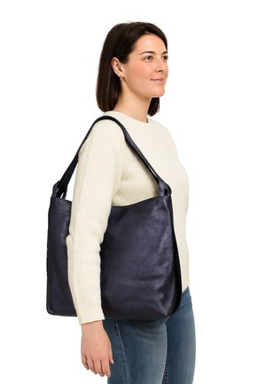 Grote marineblauwe leren tote bag met een gladde textuur, brede schouderbanden en een ontspannen vorm, gedragen op één schouder.