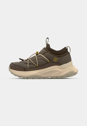 Brązowe pikowane sneakersy z szarą podeszwą, z systemem sznurowania na gumkę i teksturowanym mankietem, ozdobione logo po boku.