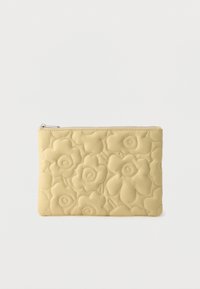 Žlté prešívané psaníčko s kvetinovým vzorom, s hladkou koženou textúrou a zipsom na vrchu.