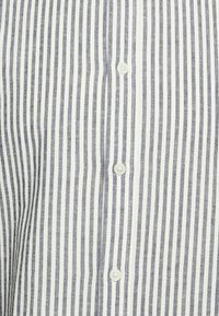 Button-up-Hemd aus leichtem Stoff mit schmalen blauen und weißen gleichmäßigen Streifen, mit einer Reihe von weißen Knöpfen auf der Vorderseite.