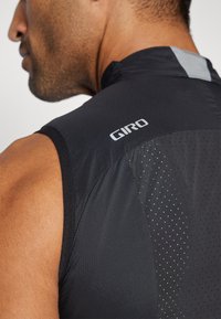 Maglia da ciclismo nera senza maniche con un tessuto liscio e una leggera lucentezza, pannelli in rete per la traspirabilità e un logo "Giro" silver.