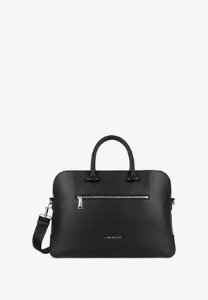 Sac en cuir noir avec texture granuleuse, double poignées, longue bandoulière amovible et poche zippée en argent à l'avant. Nom de la marque en relief.