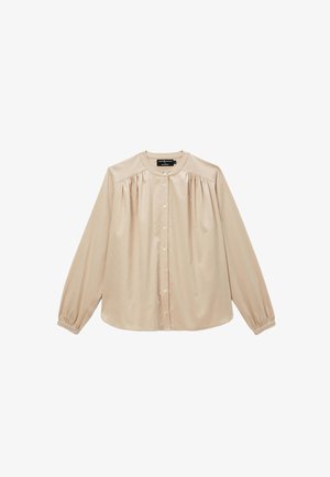 Blouse beige à manches longues en tissu doux et lisse, avec un col rond, un devant à boutons et des détails froncés aux épaules.