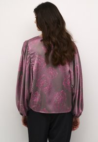 Silky blouse in grey with an all-over pink floral pattern. Features long, puffed sleeves and gathered detailing at the shoulders.