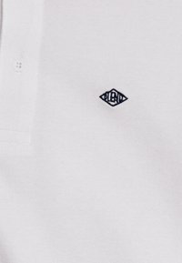 Hvit polo skjorte med et lite brodert "blend" diamantlogo i marineblått. Materialet ser mykt og strukturert ut med en klassisk krage.