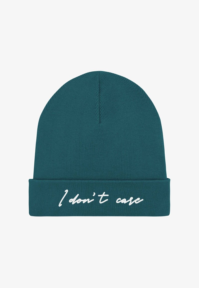 Cappello a maglia color teal con risvolto. Sul davanti presenta la scritta bianca in corsivo "I don’t care". Texture liscia, vestibilità aderente.