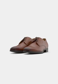 Brown leather dress shoes with a smooth finish, rounded toe, and a low black rubber heel. Features laces and minimal stitching detail.