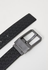 Black leather belt with embossed pattern, featuring a matte gray metal buckle with a rectangular shape and a classic pin design.