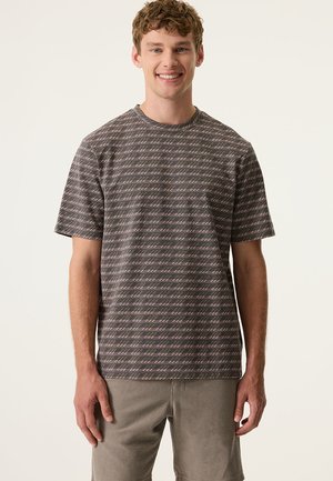 T-shirt gris à manches courtes avec un motif linéaire répétitif en rose et blanc. Coupe décontractée, encolure ronde et tissu doux au toucher.