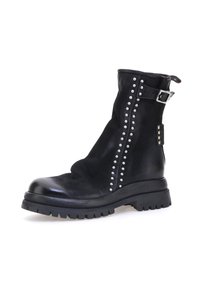 Crne kožne čizme do gležnja s teksturiranim završetkom, sa srebrnim zakovicama duž strane, remenom s kopčom i debelim potplatom.