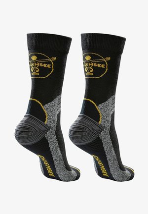 Schwarze Sportsocken mit gelben und grauen Akzenten. Mit gerippten Bündchen, verstärkter Ferse und strukturierten Griffbereichen für Stabilität.