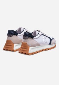 Sneakers bianchi e beige con accenti blu navy, materiali in suede e mesh, suola in gomma spessa e dettaglio "est. 1995" sul tallone.