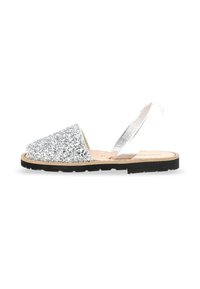 Sandal con apertura per le dita in glitter argento, con una fascia metallica, plantare in sughero e suola in gomma. Presenta una suola piatta e testurizzata.