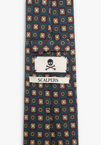Corbata con patrón que presenta un fondo azul marino con cuadrados y círculos superpuestos en rojo, amarillo y blanco. La etiqueta dice "SCALPERS" con un logo de calavera.