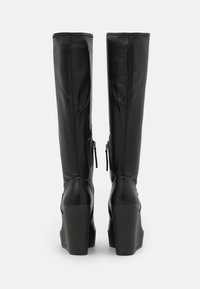 Black leather knee-high boots with a smooth finish, side zippers, and chunky heels. Simple design with no visible logos or patterns.