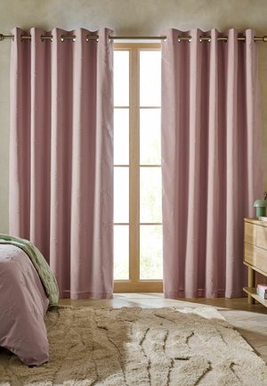 Tende rosa morbide con motivi sottili a fiocco, appese parzialmente aperte su un'asta di legno in una camera da letto con tappeto beige e mobili in legno.