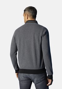 Grijze, textuurtrui met een zwarte kraag, ribbelmanchetten en onderrand. Heeft een subtiel patroon en is ontworpen voor een casual pasvorm.