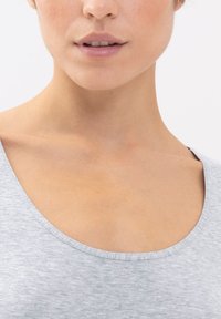 Top grigio a scollo rotondo realizzato in un tessuto morbido, caratterizzato da una texture liscia e una vestibilità comoda, che mette in evidenza la scollatura e la zona delle spalle.