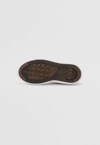 Semelle de chaussure en caoutchouc marron avec un motif texturé, dotée d'un bord blanc et d'une finition lisse. Le design détaillé améliore l'adhérence et la durabilité.