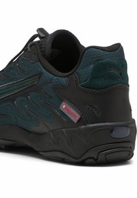 Czarno-błękitne sneakersy z teksturowaną siateczką, uformowanymi nakładkami oraz amortyzowaną podeszwą z widoczną poduszką powietrzną. Obecny detal z czerwonym logo.