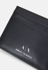 Portofel din piele neagră cu multiple sloturi pentru carduri. Prezintă un logo embosat "A/X" și "ARMANI EXCHANGE" în alb. Textură netedă și margini cusute.
