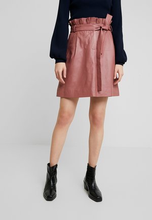 Gonna mini in pelle rosa con elastico arricciato in vita e cintura coordinata. La texture liscia e la forma svasata esaltano il design.