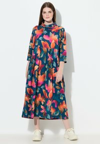 Bavlněné šaty s tyrkysovým pozadím zdobené velkými, barevnými květinovými vzory v růžové, oranžové a zelené barvě. Střední délky, s vysokým výstřihem.