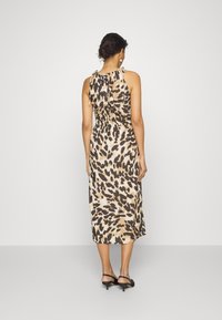 Maximekkó, sleevless, leopardprint konyhás, amely laza illeszkedésű, megkötős hátrésszel és sima selymes textúrával rendelkezik. Színpalettája bézs és barna árnyalatokat tartalmaz.