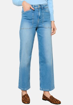 Light blue wide-leg jeans with front pockets, a high waistline, and finished hems, paired with leopard print slip-on shoes.