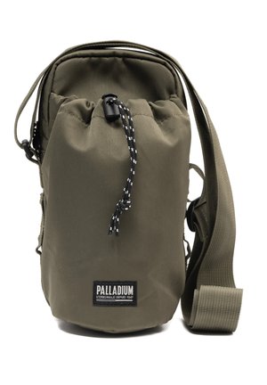 Petit sac bandoulière vert olive avec sangle ajustable, fermeture à cordon et étiquette de la marque Palladium sur le devant.