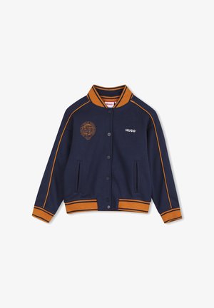Veste bleu marine à boutons avec bordure orange, col et poignets côtelés, poches avant, logo Hugo sur la poitrine et emblème globe sur le côté gauche.