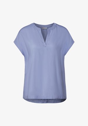 Světle modrá krátkosrstá blůza s výstřihem do V. Vyrobena z hladké látky, má pohodlný střih a zakřivený lem na spodním okraji.