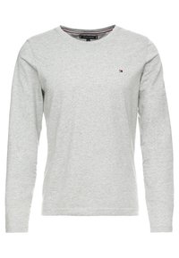 Graues langärmliges T-Shirt aus weicher Baumwolle mit rundem Halsausschnitt und kleinem Logo auf der linken Brust. Glatte Textur.