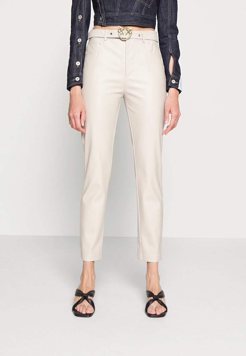 Beiga faux läderbyxor med skräddarsydd passform, med sidofickor och en guldspänne bälte som accent. Styler med svarta remsandaler.