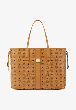 Brun tote bag lavet af læder med præget logo-mønster. Har et gyldent emblem, to håndtag og en lynlås side lomme.