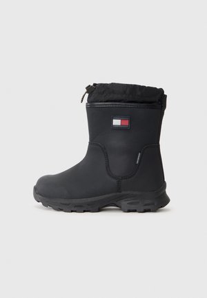 Mustat vedenpitävät saappaat, joissa on teksturoitu kumipohja, joustava yläosa ja logo-ompelus. Sileä päällismateriaali, vahvistetut saumat ja käytännöllinen muotoilu.