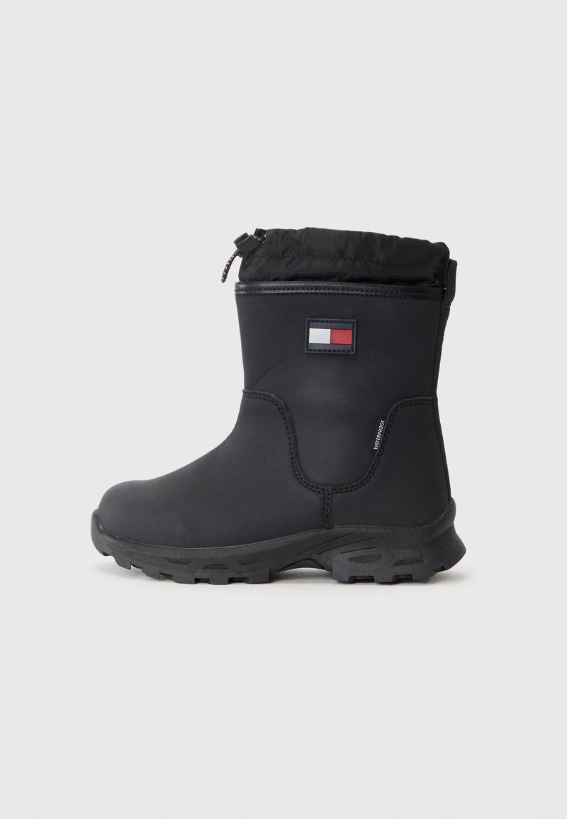 Botas de agua negras, impermeables, con una suela de goma texturizada, parte superior elástica y un parche con logo. Material superior liso, costuras reforzadas y diseño práctico.