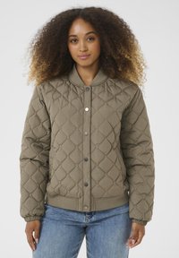 Veste bomber matelassée olive avec fermetures à pression, poignets et ourlet côtelés, en tissu doux et texturé avec un col rond.