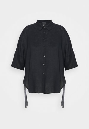 Zwart linnen overhemd met korte mouwen, knoopsluiting aan de voorkant en zijstrikjes. Heeft een ontspannen pasvorm en een licht gebogen zoom.
