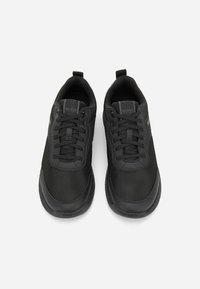 Svarta träningsskor med en ovandel i mesh, gummisula och kontrasterande texturerade paneler. Inkluderar snördesign och logotypdetaljer.