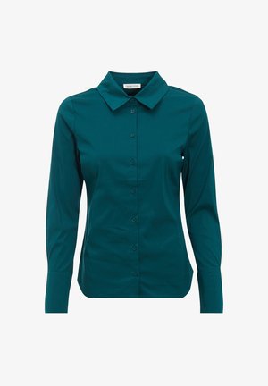 Blouse bleu sarcelle à manches longues avec col pointu, taille ajustée et poignets boutonnés sur fond blanc.
