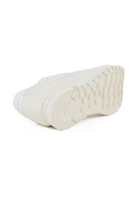 Baskets blanches avec un dessus texturé, un bout rond et une semelle en caoutchouc épaisse avec un motif de semelle. Accentué par un logo discret.