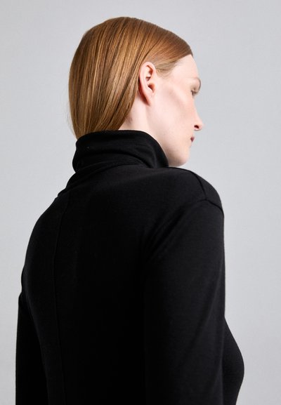 Mustat poolopaita, jossa on kiinteä malli, sileä pinta ja pitkät hihat. Sisältää korkean kauluksen ja takasauman yksityiskohdat.