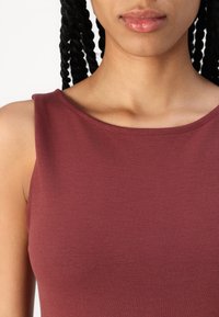 Top sans manches bourgogne en tissu lisse, présentant un col rond et un design simple, avec une coupe ajustée.